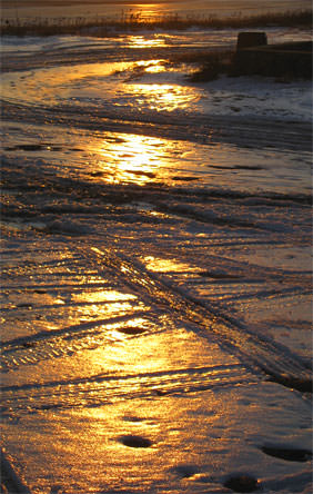 icy tire tracks at sunset