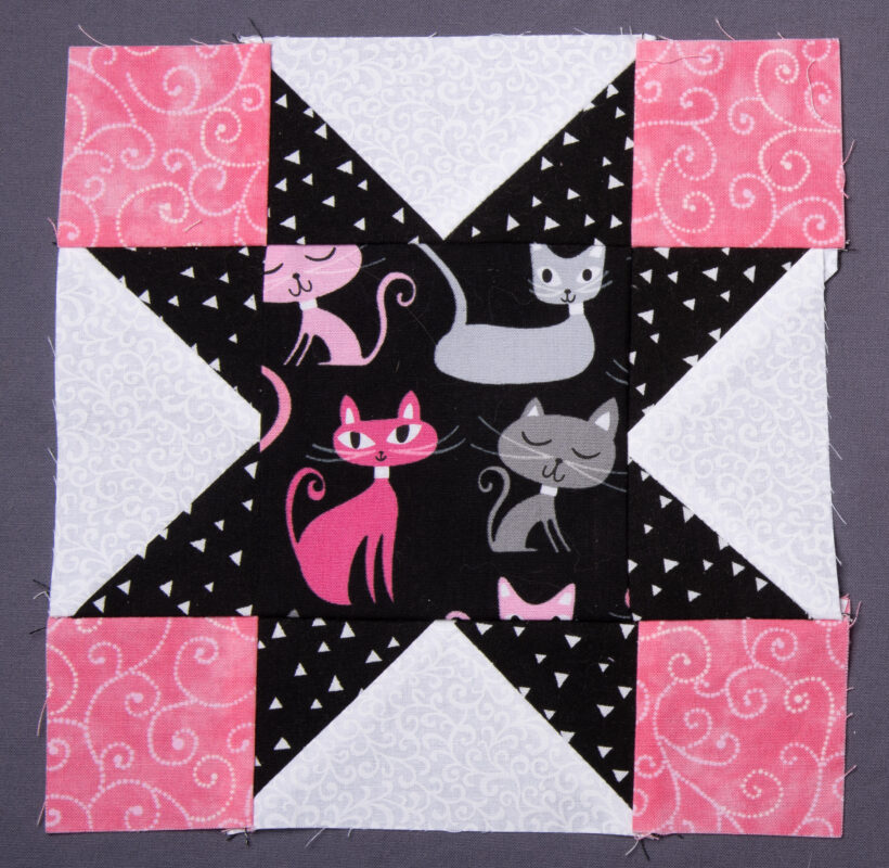 Variable Star quilt block featuring pink kitties in the middle