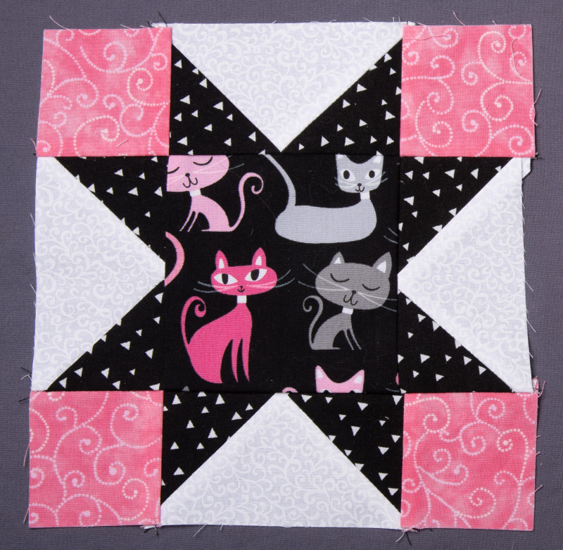 Variable Star quilt block featuring pink kitties in the middle